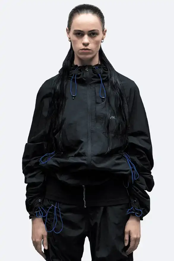 RADIO ECHOES: A-COLD-WALL* TUNES INTO UK ROOTS FOR SS25 pic of A-COLD-WALL*'s Spring/Summer 2025 collection called "Pink Noise," which draws inspiration from British radio culture. The piece describes the collection's technical outerwear, including utility jackets with toggles and drawstrings, ice blue collared jackets paired with loose shirts, color-blocked knitwear in black, brown and cream, graphic t-shirts, ribbed vests, and practical sling bags. The article notes that this collection follows the departure of founder Samuel Ross and the brand's acquisition by Four Marketing. The collection maintains A-COLD-WALL*'s signature gorpcore aesthetic with functional designs and is currently available on the brand's website. (image 4 of 9)
