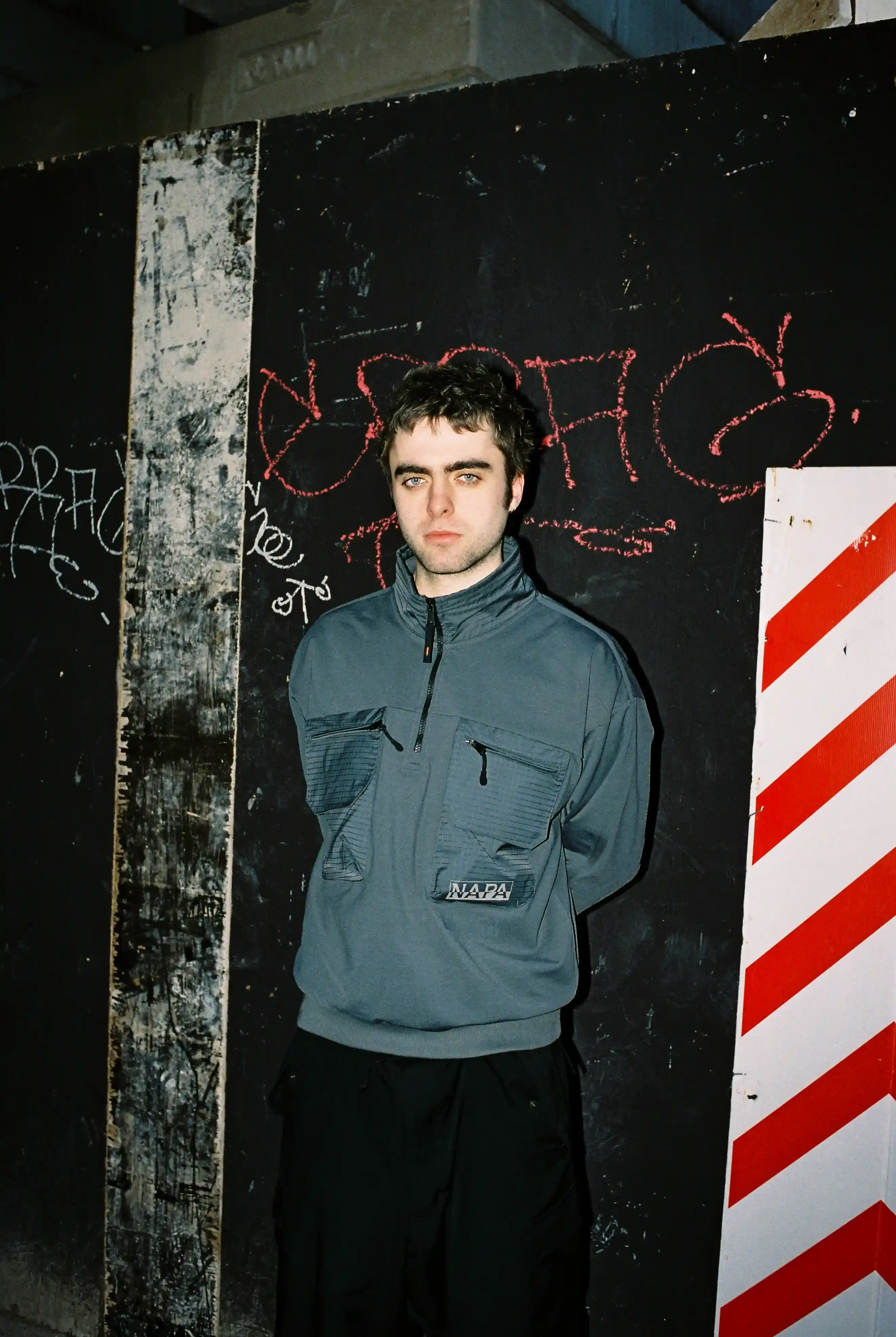© Casawi | quadronnodistrict image of Lennon Gallagher, featuring a Q&A format discussion about his modeling work with Napapijri, his band activities, daily routines, and personal influences including David Bowie. The article reveals his casual approach to life, balancing music practice with modeling, and his preference for a laid-back lifestyle. shoot by quadronnodistrict (image 8 of 13)