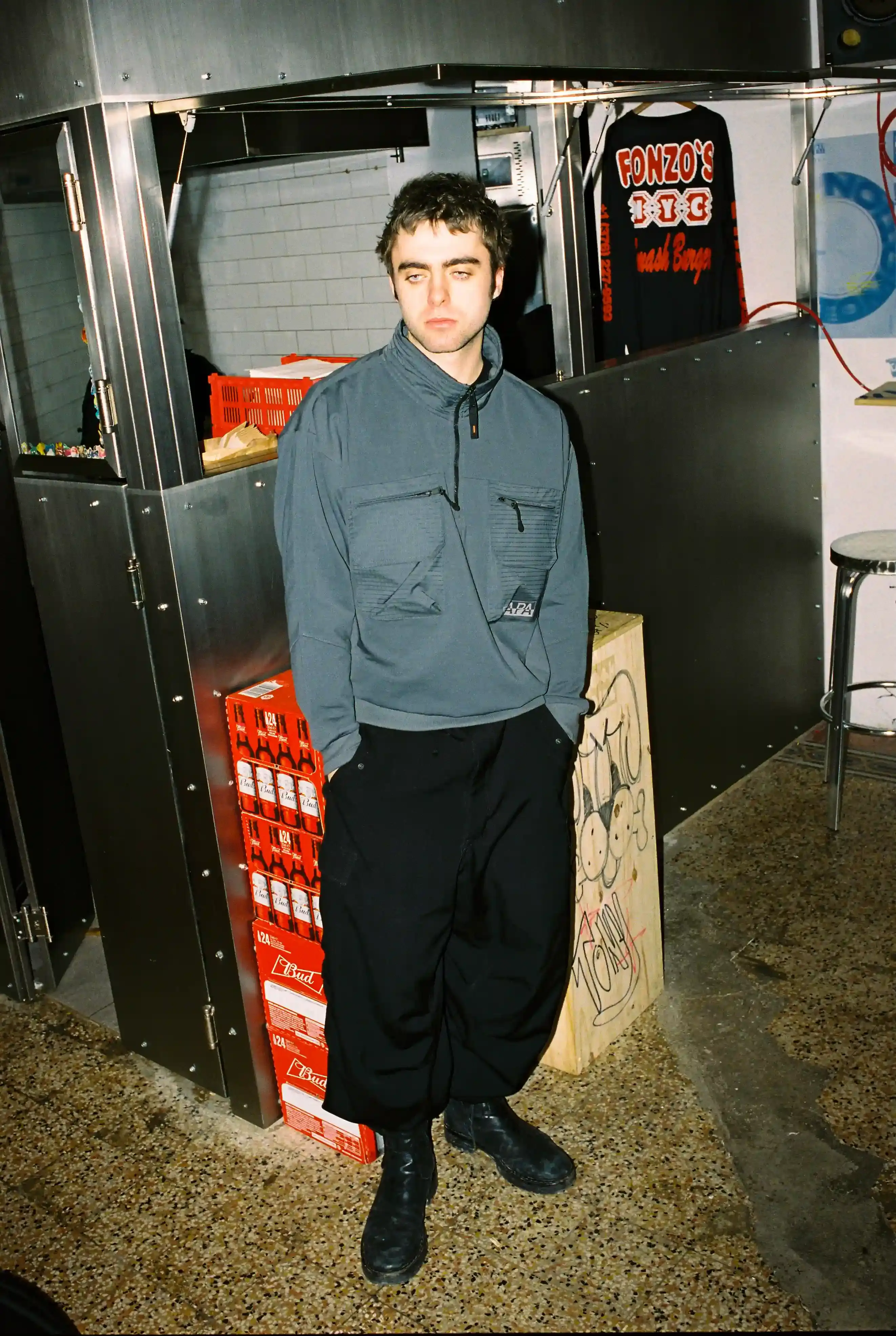 © Casawi | quadronnodistrict image of Lennon Gallagher, featuring a Q&A format discussion about his modeling work with Napapijri, his band activities, daily routines, and personal influences including David Bowie. The article reveals his casual approach to life, balancing music practice with modeling, and his preference for a laid-back lifestyle. shoot by quadronnodistrict (image 12 of 13)
