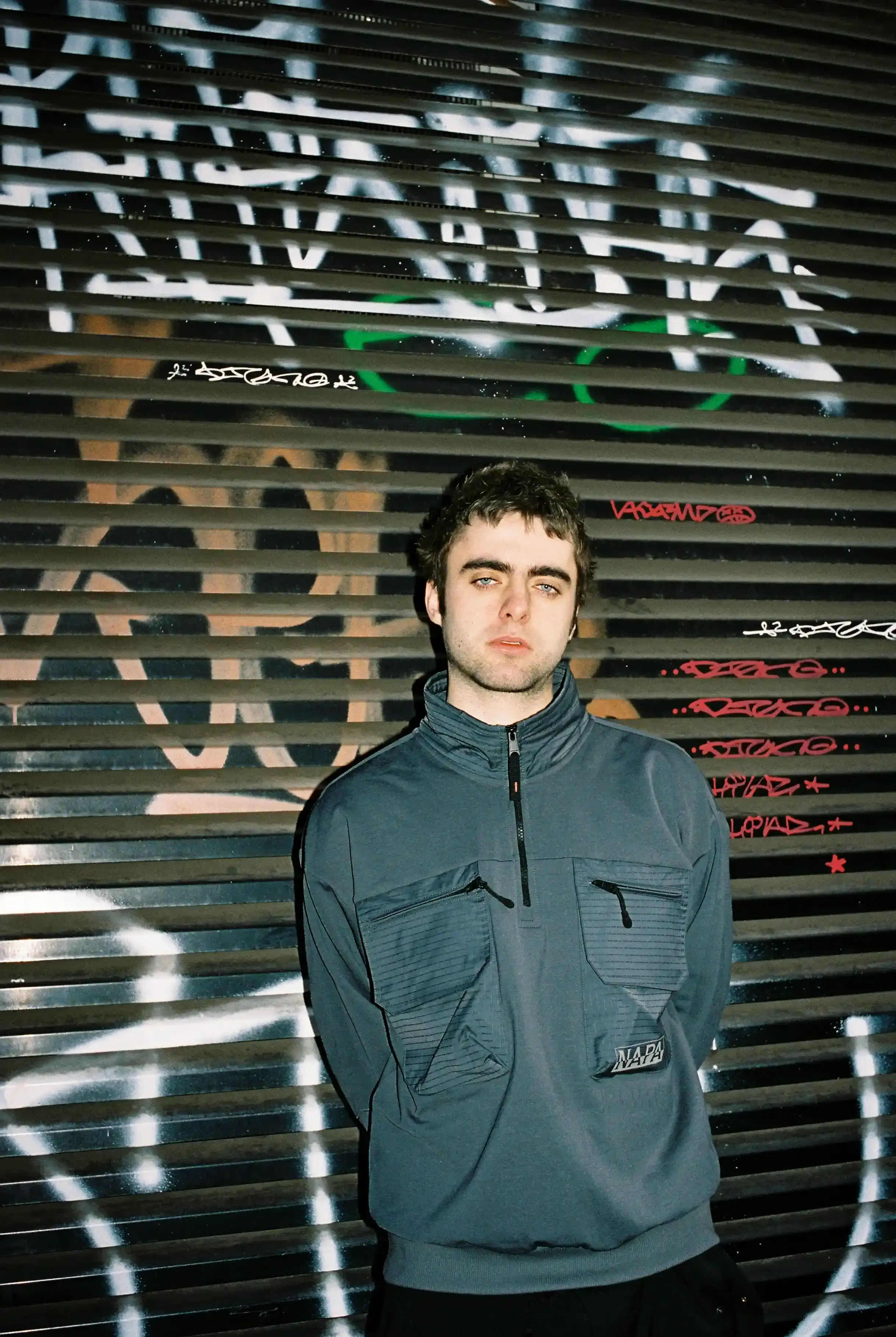 © Casawi | quadronnodistrict image of Lennon Gallagher, featuring a Q&A format discussion about his modeling work with Napapijri, his band activities, daily routines, and personal influences including David Bowie. The article reveals his casual approach to life, balancing music practice with modeling, and his preference for a laid-back lifestyle. shoot by quadronnodistrict (image 9 of 13)