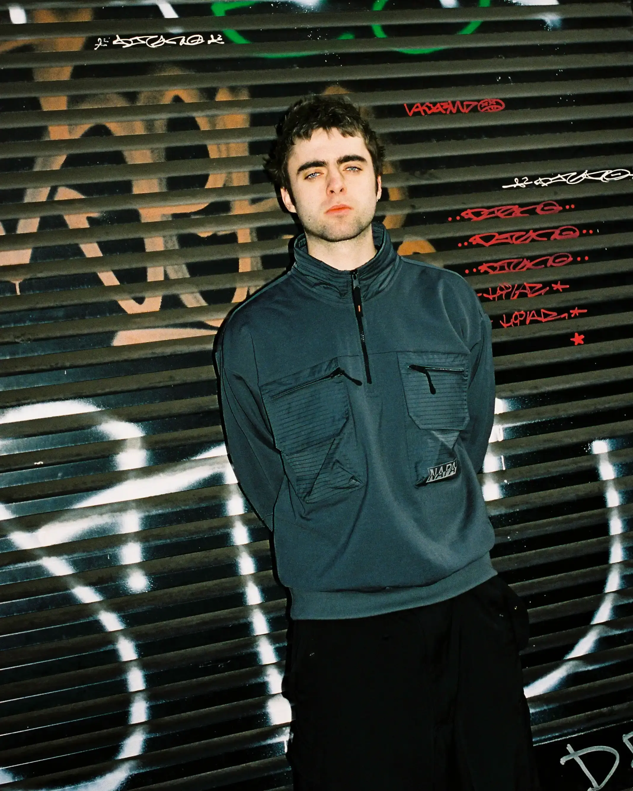 © Casawi | quadronnodistrict image of Lennon Gallagher, featuring a Q&A format discussion about his modeling work with Napapijri, his band activities, daily routines, and personal influences including David Bowie. The article reveals his casual approach to life, balancing music practice with modeling, and his preference for a laid-back lifestyle. shoot by quadronnodistrict (image 10 of 13)