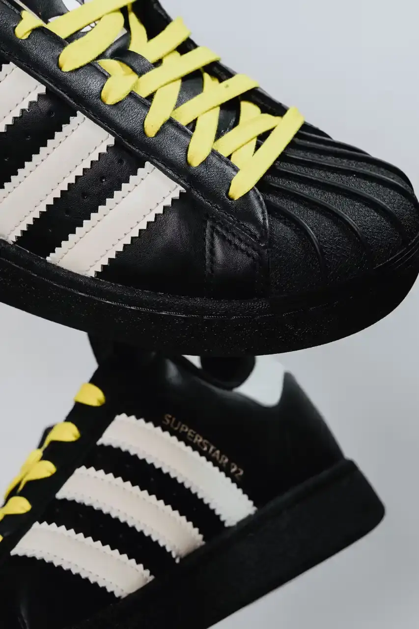 A Ma Maniére The Pharrell x adidas Virginia Superstar 92 sneaker in Off White colorway, showing its oversized silhouette with thick padding and classic shell toe design against a neutral background. (image 6 of 6)