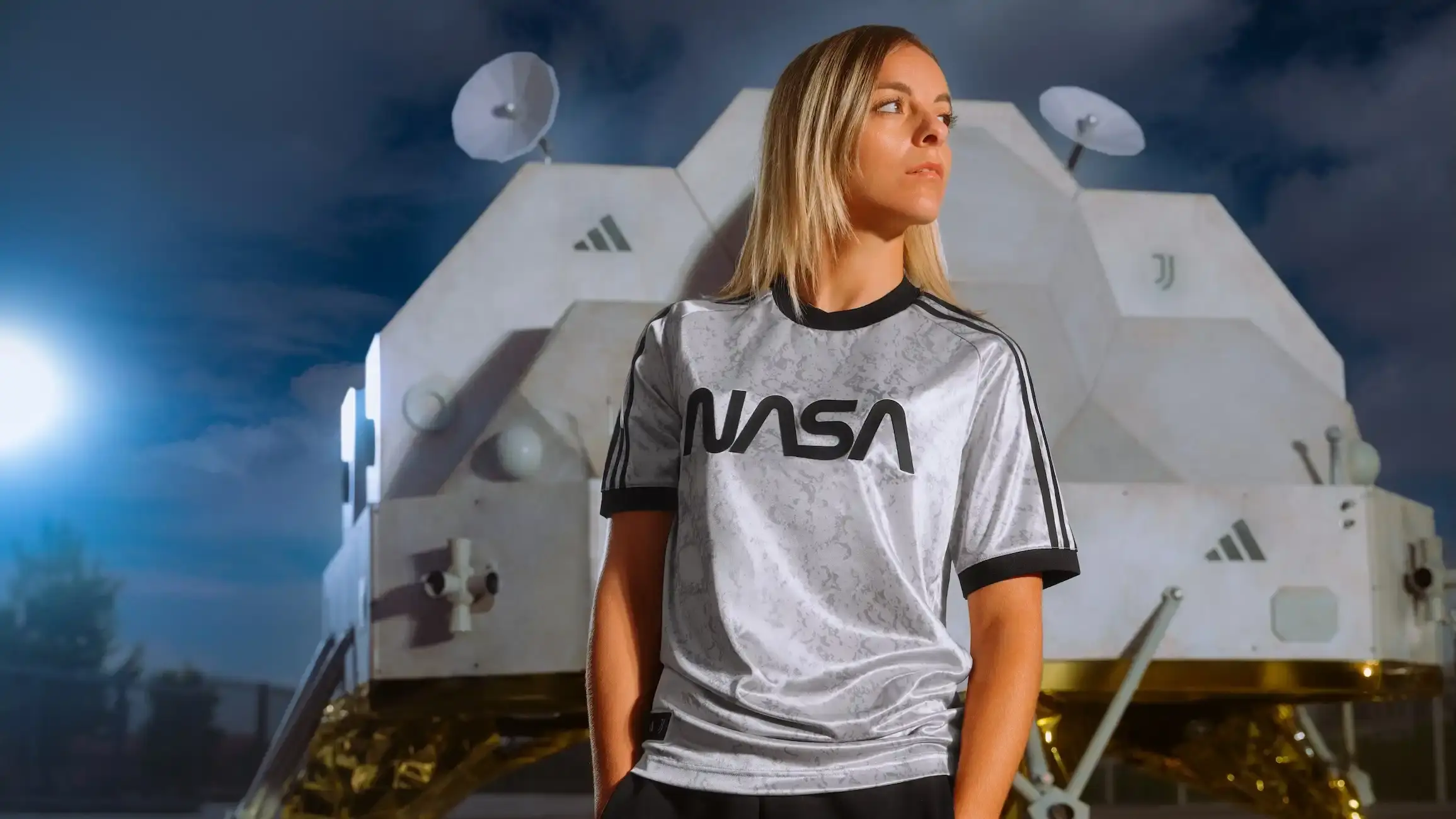 adidas x Juventus NASA collection display showing jerseys, bomber jackets and suits against a dark background with subtle space elements