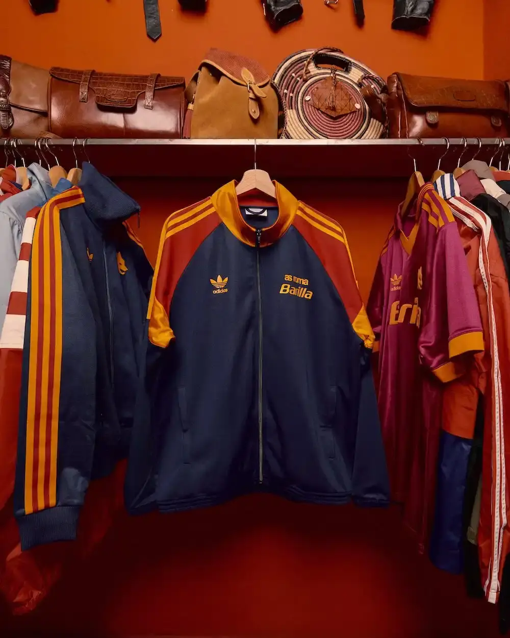 adidas Originals Image shows AS Roma 1990s retro football jersey in classic yellow and red colors, featuring Trefoil logo, Lupetto wolf emblem, and Barilla sponsor, representing Adidas Originals' heritage collection.