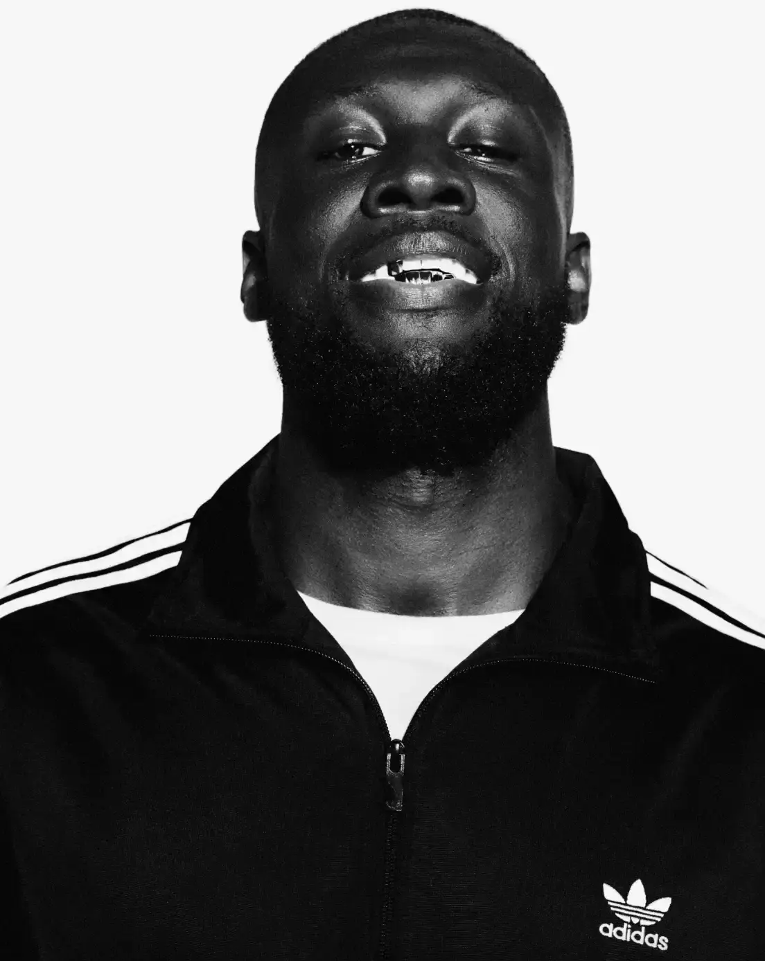 ADIDAS SUPERSTAR CAMPAIGN STARS STORMZY, BELLINGHAM, KEOGHAN image covers Adidas campaign featuring celebrities wearing iconic Superstar sneakers and Firebird tracksuits in black and white photography. (image 3 of 18)