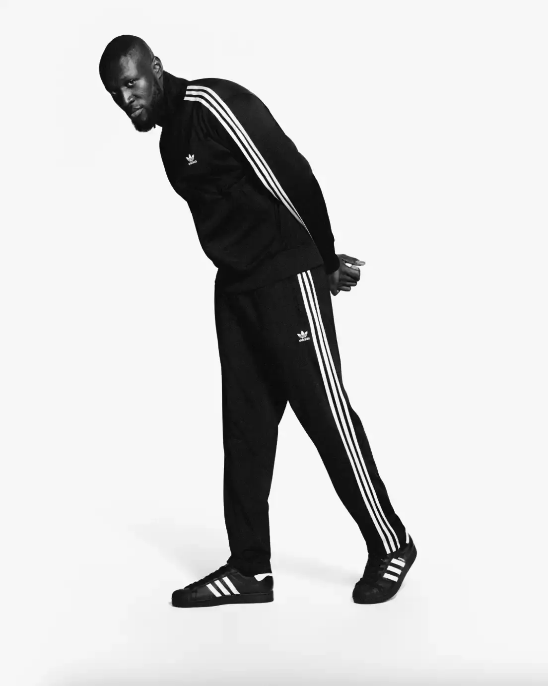 ADIDAS SUPERSTAR CAMPAIGN STARS STORMZY, BELLINGHAM, KEOGHAN image covers Adidas campaign featuring celebrities wearing iconic Superstar sneakers and Firebird tracksuits in black and white photography. (image 4 of 18)