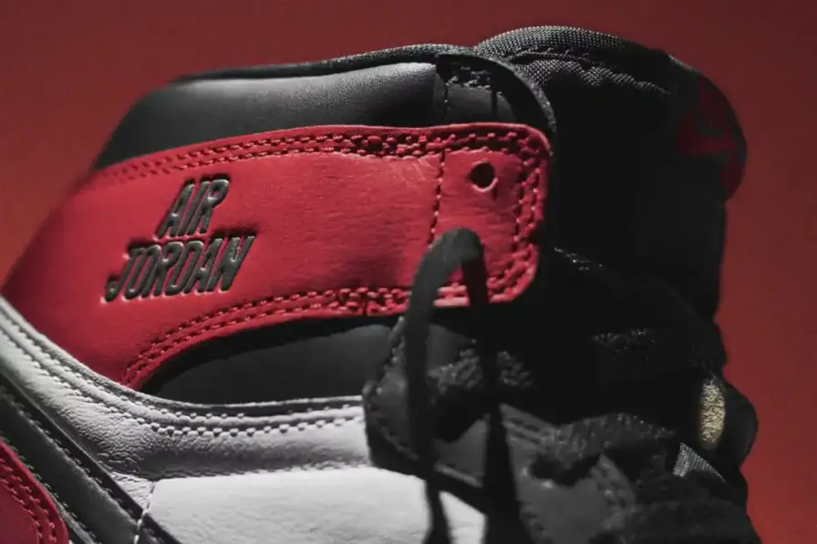 Nike Article about the Air Jordan 1 'Black Toe Reimagined' sneaker launching February 15, 2025. The shoe features white leather with black and red accents, commemorative text from Jordan's rookie season, and releases for $180 during NBA All-Star Weekend." (image 2 of 9)