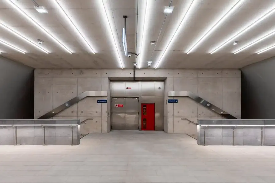 ANISH KAPOOR'S NAPLES SUBWAY STATION OPENS TODAY Two contrasting subway station entrances in Naples designed by Anish Kapoor: one features curved weathering steel panels with organic texture rising from plaza pavement, the other shows a sunken aluminum tube entrance with brushed metal finish reflecting surrounding buildings (image 5 of 7)