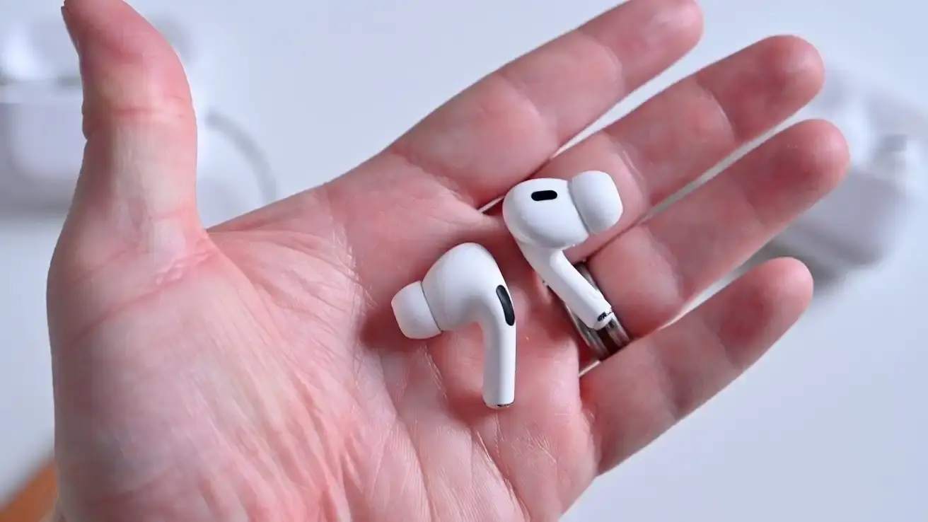 Article about Apple's development of camera-equipped AirPods that would enhance Apple Intelligence features and potentially serve as an alternative to smart glasses for environmental sensing and AI-powered assistance.