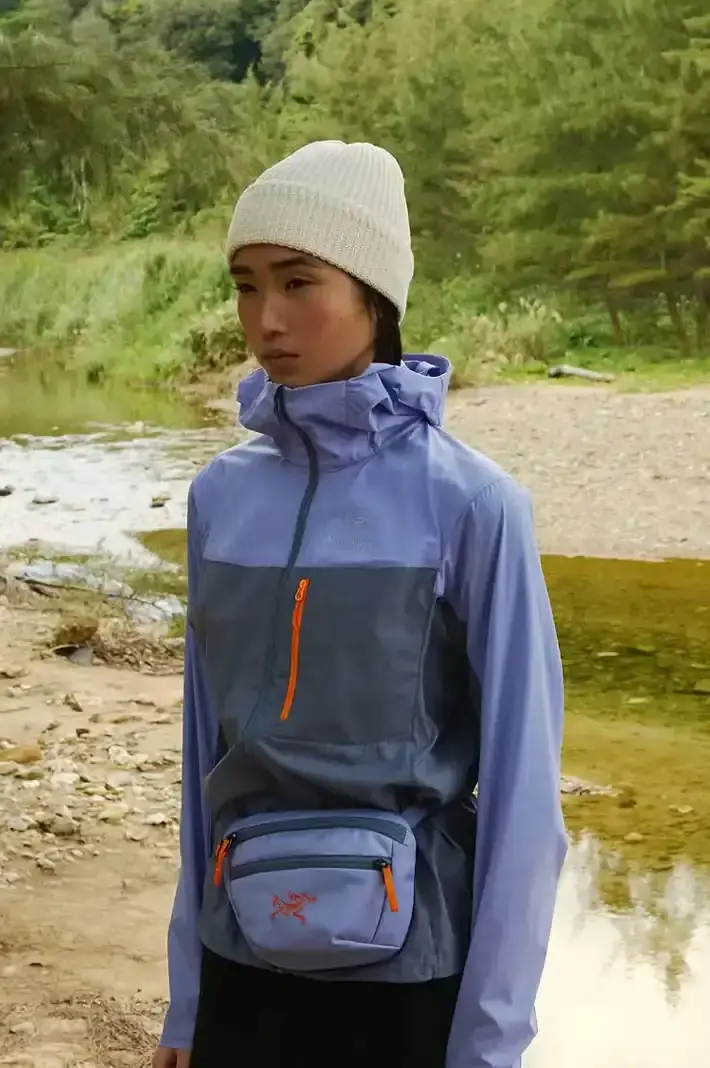ARC'TERYX ARC'TERYX x BEAMS BOY Twilight Trail collection featuring lavender and yellow Beta Jackets, Squamish Hoodies, Mantis 1 Waist Packs, and Mantis 26 Backpacks arranged on a neutral background. (image 4 of 7)