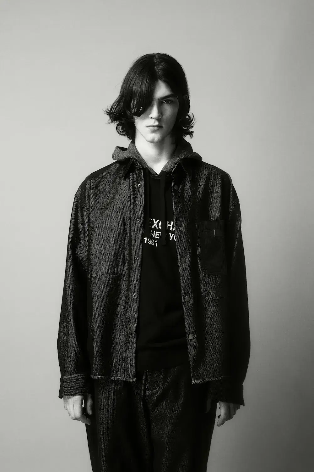 ARMANI EXCHANGE RELAUNCHES BASICS CAMPAIGN Black and white portrait photography from the Armani Exchange Basics campaign set against a neutral studio background. (image 5 of 16)
