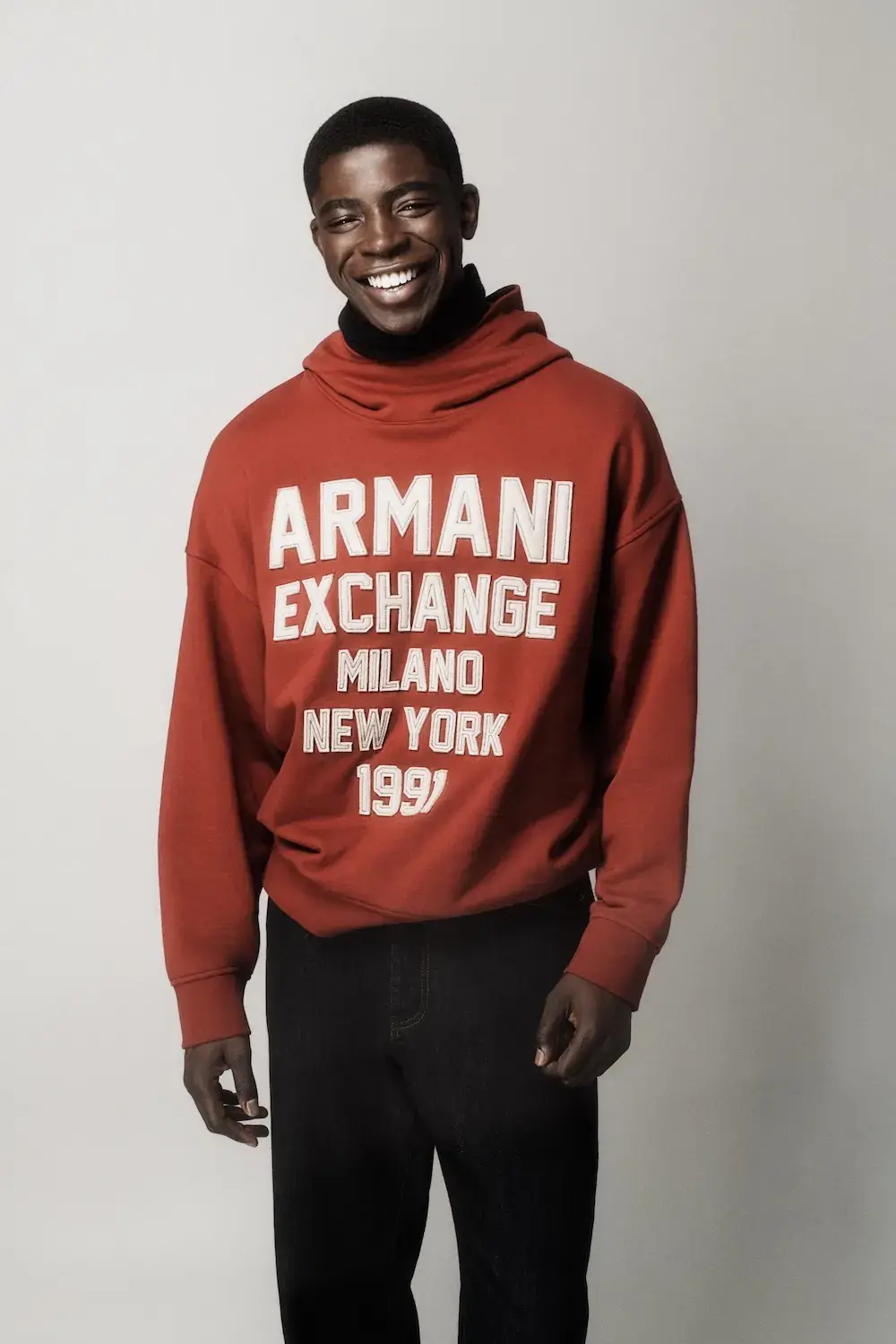 ARMANI EXCHANGE RELAUNCHES BASICS CAMPAIGN Black and white portrait photography from the Armani Exchange Basics campaign set against a neutral studio background. (image 3 of 16)