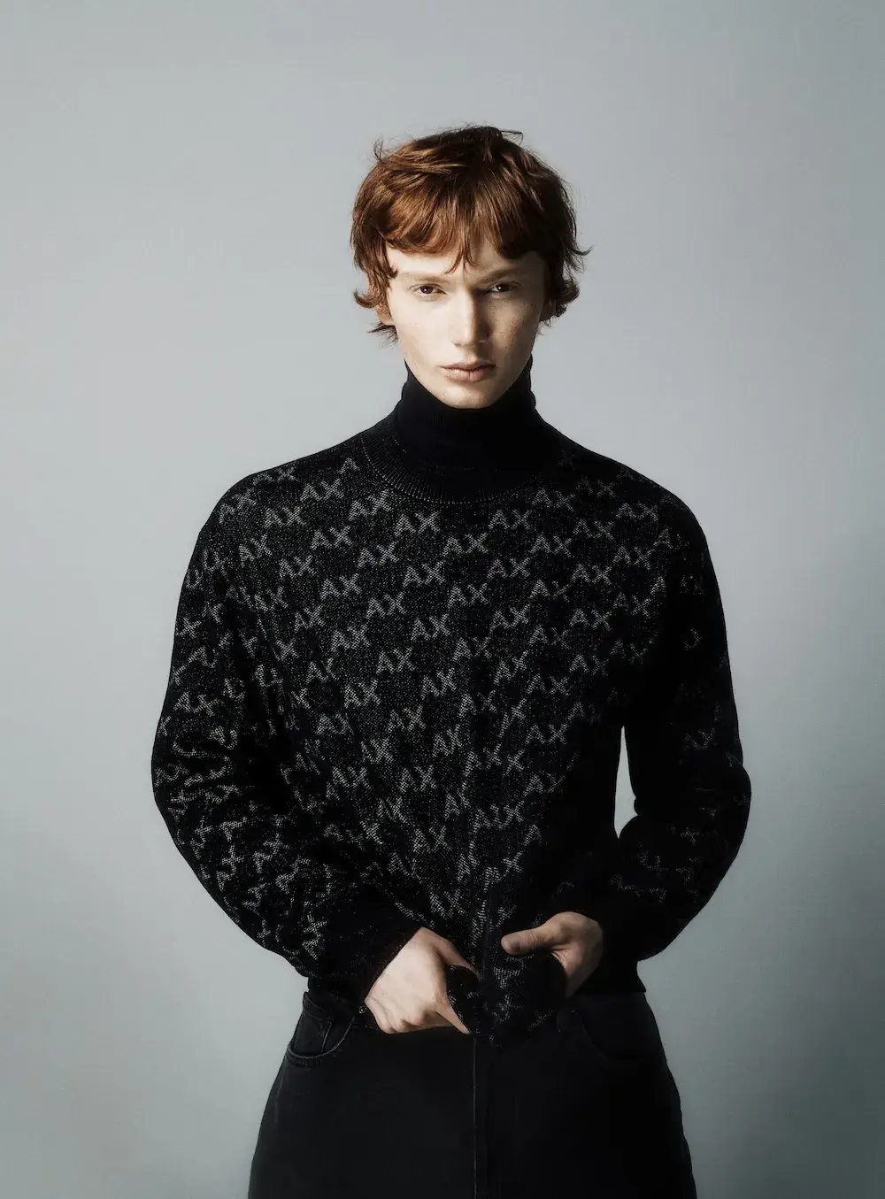 ARMANI EXCHANGE RELAUNCHES BASICS CAMPAIGN Black and white portrait photography from the Armani Exchange Basics campaign set against a neutral studio background. (image 6 of 16)