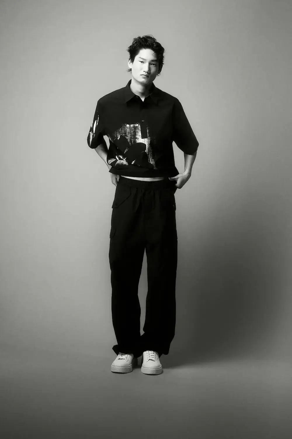 ARMANI EXCHANGE RELAUNCHES BASICS CAMPAIGN Black and white portrait photography from the Armani Exchange Basics campaign set against a neutral studio background. (image 2 of 16)