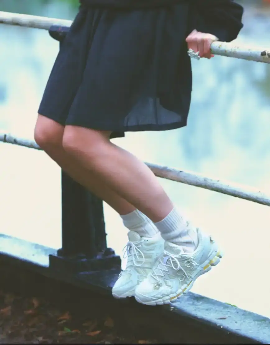 ASICS AND COMPLETEDWORKS RELEASE GEL-KAYANO 20 COLLABORATION A photograph shows a pair of ASICS GEL-KAYANO 20 sneakers modified with sculptural jewelry elements like pearls and floral motifs. (image 2 of 6)