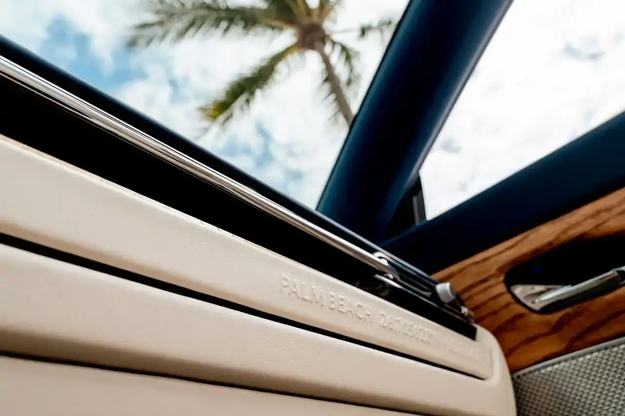 ASTON MARTIN CREATES BESPOKE DB12 FOR FLORIDA MARKET image of Aston Martin's custom DB12 Volante convertible designed for the Florida market, featuring specialized blue paint with glass particles, white accent striping, and interior elements inspired by Palm Beach including palm leaf motifs and regional coordinates. (image 8 of 13)