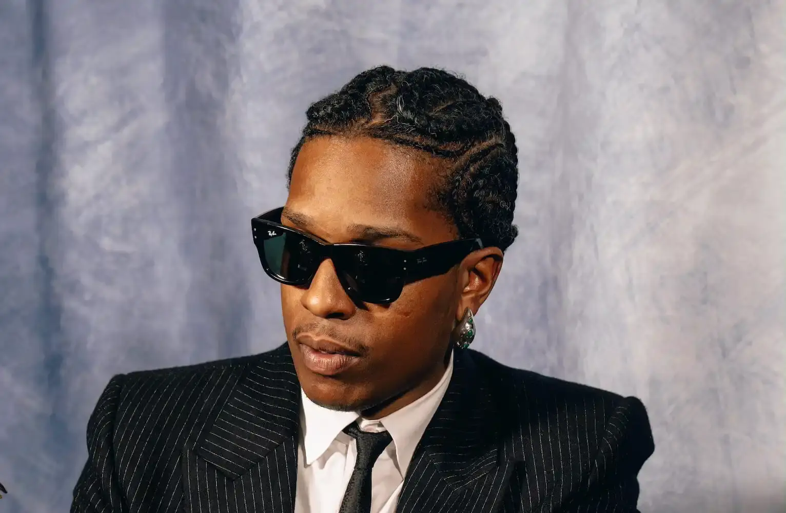 A$AP Rocky wearing Ray-Ban sunglasses, looking directly at camera with a serious expression