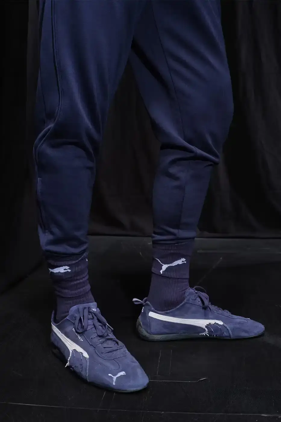 Balenciaga Balenciaga x PUMA collection display showing the Ultrasoft Speedcat sneakers in three colorways alongside tracksuits, outerwear pieces, and accessories arranged on a neutral background. (image 18 of 21)