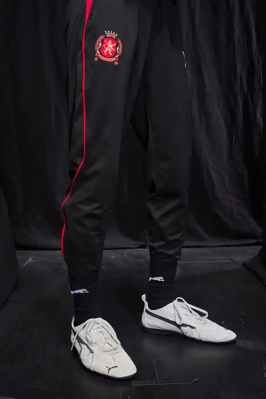 Balenciaga Balenciaga x PUMA collection display showing the Ultrasoft Speedcat sneakers in three colorways alongside tracksuits, outerwear pieces, and accessories arranged on a neutral background. (image 20 of 21)