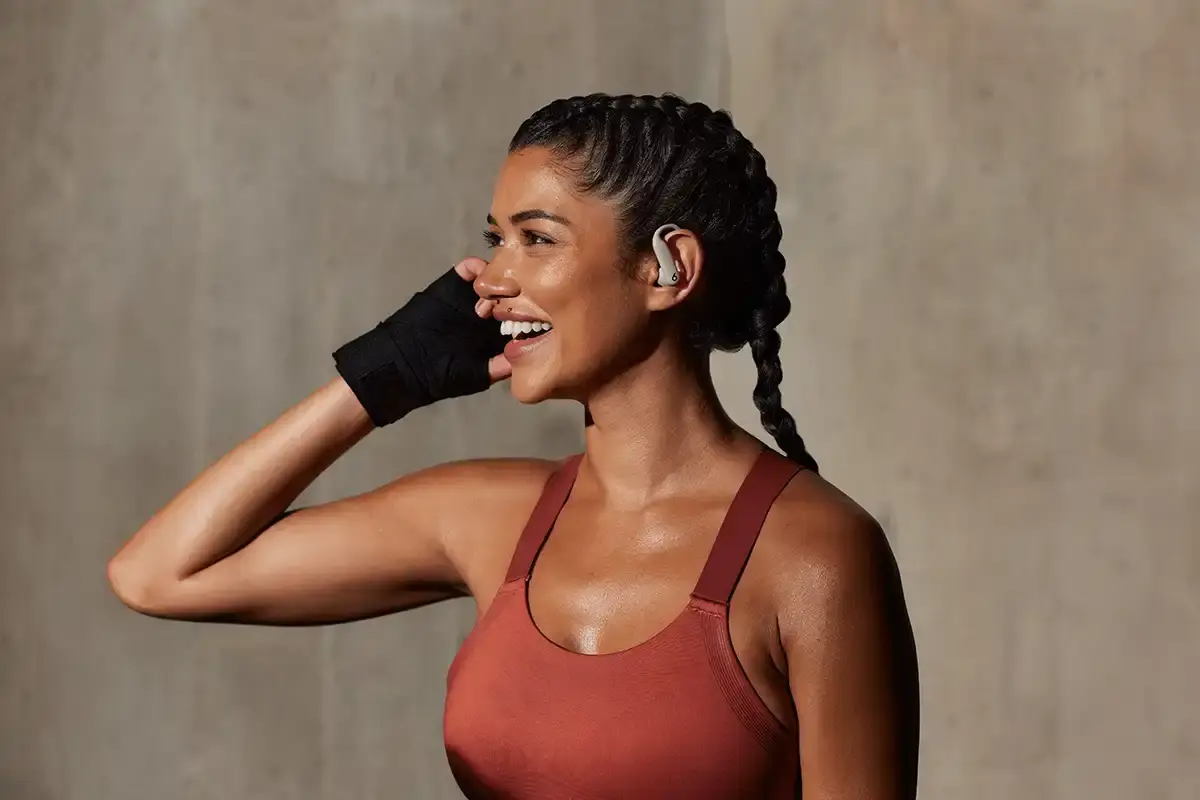 Beats Powerbeats Pro 2 wireless earphones in Electric Purple color, showing ear hooks and charging case with wireless charging capability.