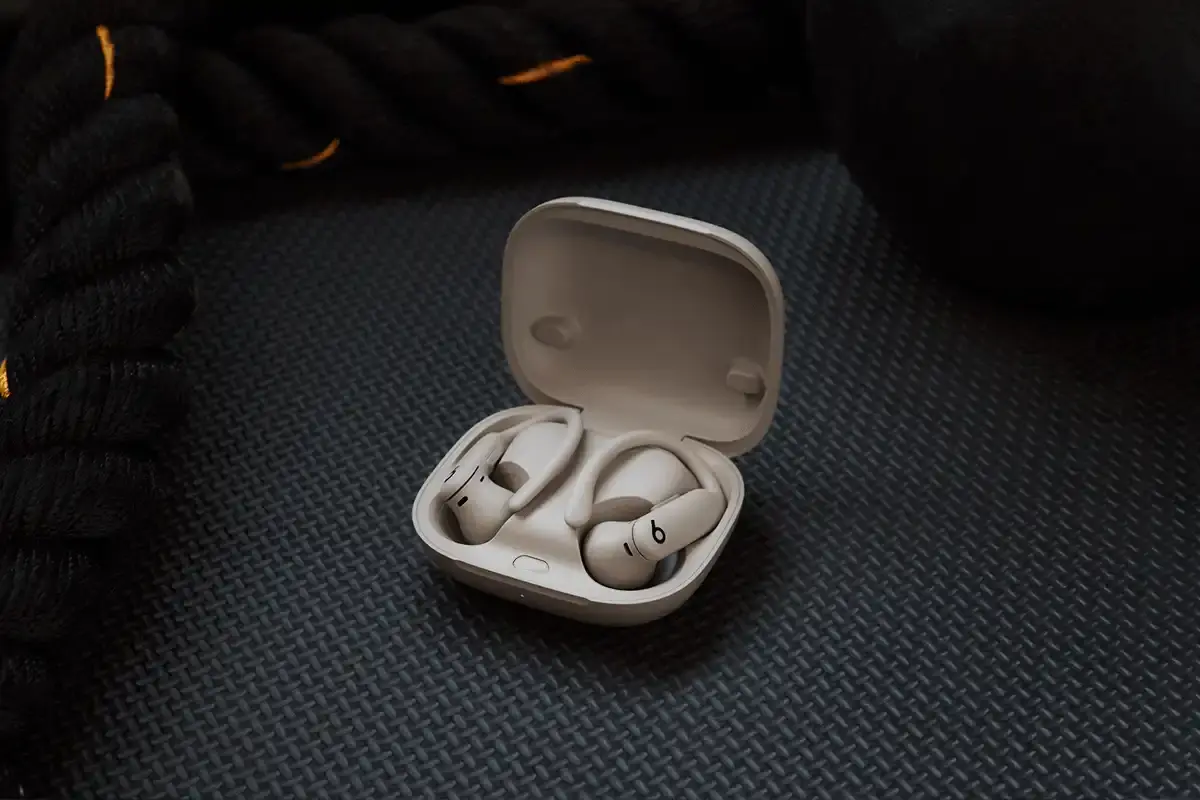 Beats Powerbeats Pro 2 wireless earphones in Electric Grey color, showing ear hooks and charging case with wireless charging capability.