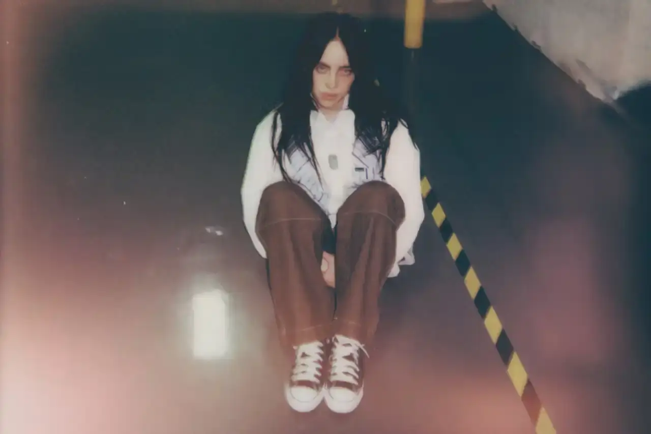 BILLIE EILISH COLLABORATES WITH CONVERSE ON CUSTOMIZABLE SNEAKER LINE Billie Eilish partners with Converse to launch a customizable sneaker line featuring personalized Chuck Taylor All Star and Chuck Taylor Lift Platform models. The collection includes ice-blue transparent soles with Eilish's album name, options to add song lyrics to midsoles, and various design elements like embroidered mascots and colored stars. Available exclusively on Converse's website, this collaboration offers fans a unique way to express themselves through personalized footwear inspired by Eilish's music and style. (image 4 of 7)