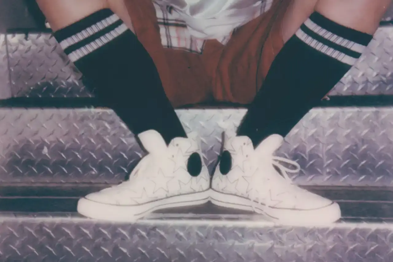 BILLIE EILISH COLLABORATES WITH CONVERSE ON CUSTOMIZABLE SNEAKER LINE Billie Eilish partners with Converse to launch a customizable sneaker line featuring personalized Chuck Taylor All Star and Chuck Taylor Lift Platform models. The collection includes ice-blue transparent soles with Eilish's album name, options to add song lyrics to midsoles, and various design elements like embroidered mascots and colored stars. Available exclusively on Converse's website, this collaboration offers fans a unique way to express themselves through personalized footwear inspired by Eilish's music and style. (image 2 of 7)
