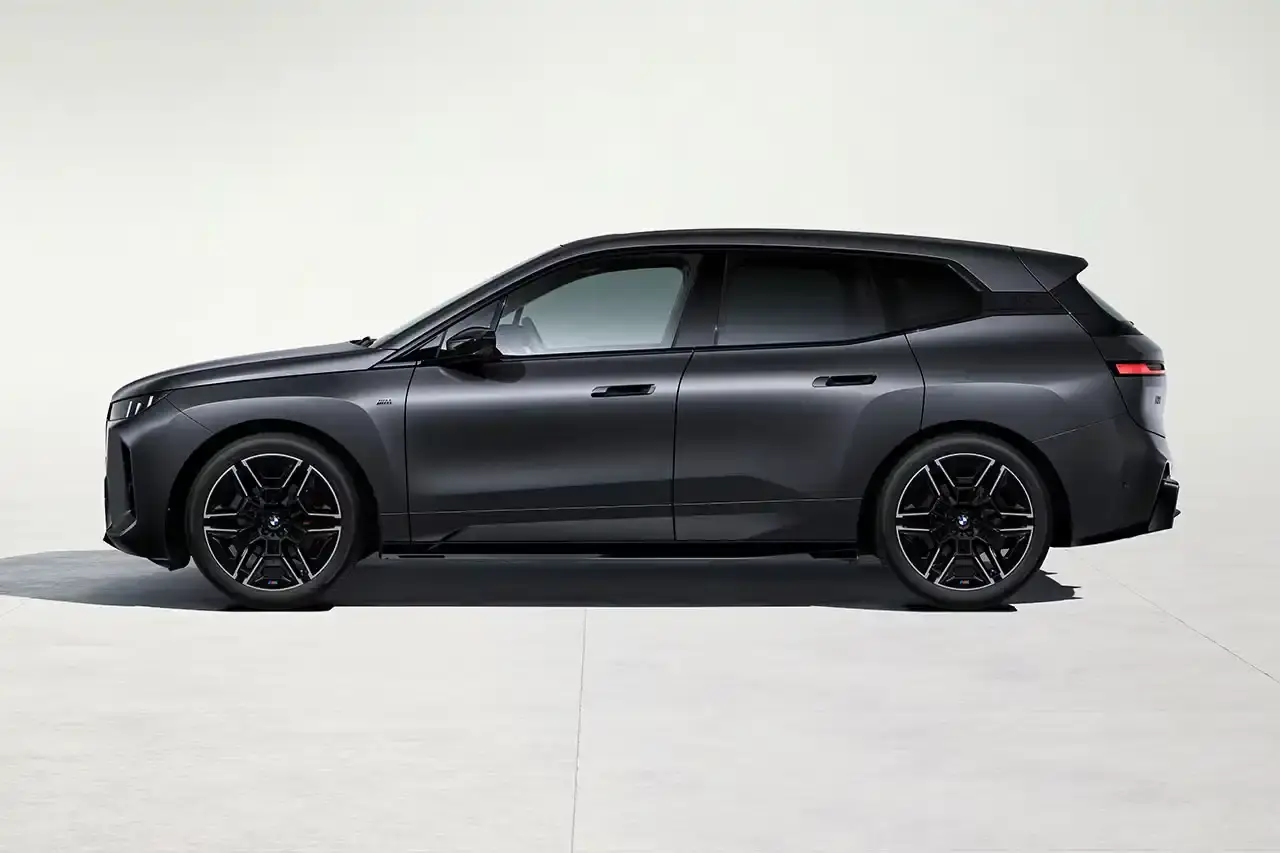 BMW BMW iX M70 xDrive electric SUV in front three-quarter view, showing darkened kidney grille with M badge and black exterior mirrors (image 2 of 11)