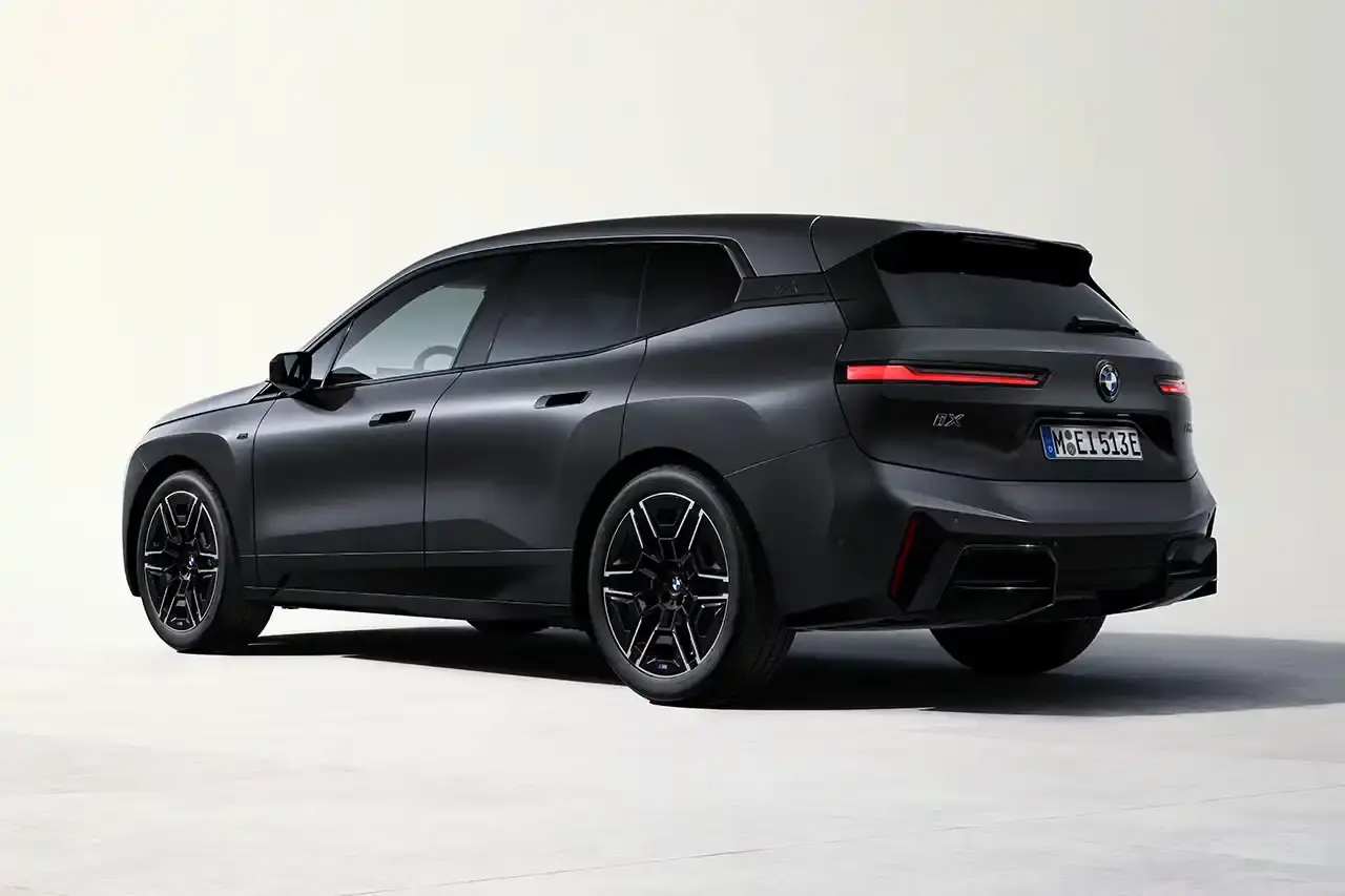 BMW BMW iX M70 xDrive electric SUV in front three-quarter view, showing darkened kidney grille with M badge and black exterior mirrors (image 3 of 11)