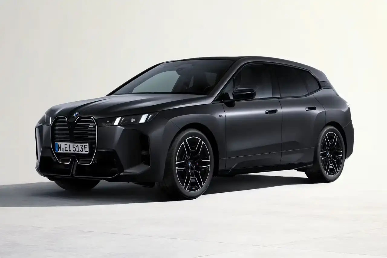 BMW BMW iX M70 xDrive electric SUV in front three-quarter view, showing darkened kidney grille with M badge and black exterior mirrors