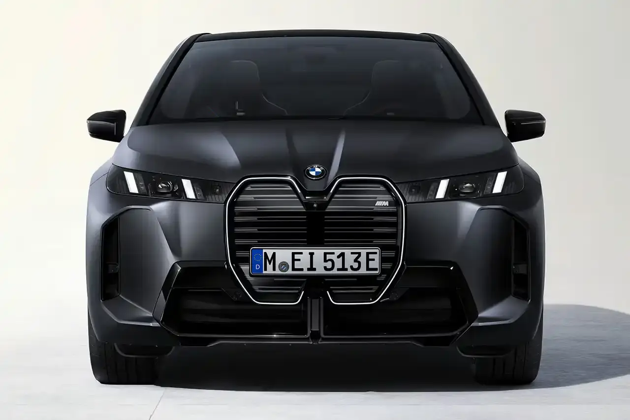 BMW BMW iX M70 xDrive electric SUV in front three-quarter view, showing darkened kidney grille with M badge and black exterior mirrors (image 5 of 11)