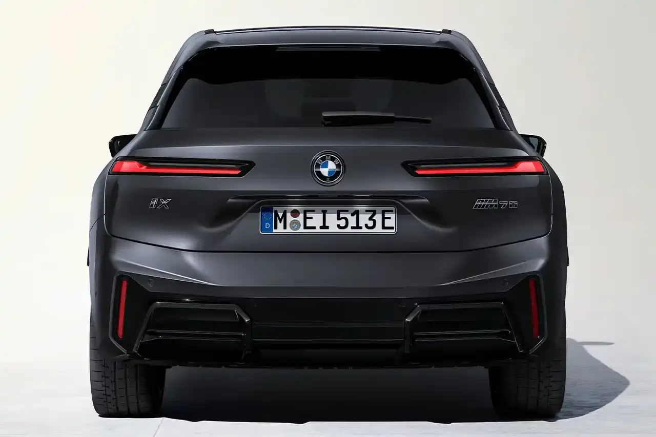 BMW BMW iX M70 xDrive electric SUV in front three-quarter view, showing darkened kidney grille with M badge and black exterior mirrors (image 4 of 11)