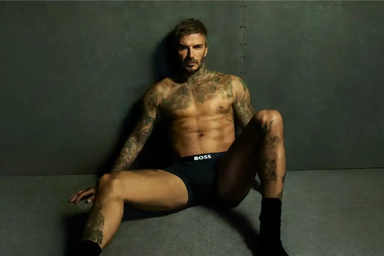 Boss David Beckham wearing white BOSS ONE boxer briefs while seated in a minimalist New York apartment, photographed in black and white