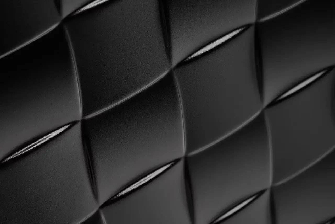Bottega Veneta Bottega Veneta Odyssey carry-on suitcase with textured polycarbonate shell featuring 3D Intreccio pattern, silver hardware, and brown calfskin leather handles. The wheeled luggage is shown in a three-quarter view displaying its structured design and branded details. (image 7 of 7)