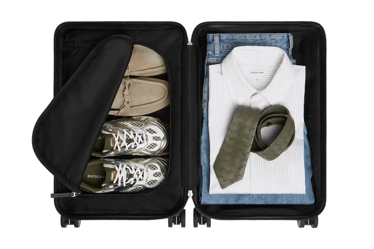 Bottega Veneta Bottega Veneta Odyssey carry-on suitcase with textured polycarbonate shell featuring 3D Intreccio pattern, silver hardware, and brown calfskin leather handles. The wheeled luggage is shown in a three-quarter view displaying its structured design and branded details. (image 2 of 7)