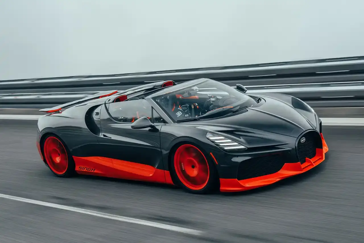 Bugatti Bugatti, the renowned manufacturer of high-performance luxury automobiles, has once again pushed the boundaries of automotive engineering with the remarkable achievements of its W16 Mistral model. On November 9th, the W16 Mistral set a new world record for the fastest open-top car, reaching a staggering speed of 453.91 km/h (281 mph) at the ATP Automotive Testing Papenburg track in Germany. The record-breaking run was piloted by Andy Wallace, Bugatti's official test driver and a renowned Le Mans winner, showcasing the exceptional capabilities of the W16 Mistral. This remarkable feat builds upon Bugatti's legacy of record-setting performance, including the Veyron 16.4 Grand Sport Vitesse's 408.84 km/h (253 mph) record achieved in 2013 and the Chiron Super Sport 300+'s 490.48 km/h (304 mph) closed-cockpit record set in 2019. The W16 Mistral, a bespoke $14.8 million USD model, features a striking black carbon body with "Jet Orange" accents, paying homage to Bugatti's previous record-setting vehicles. The event was attended by Mate Rimac, CEO of Bugatti Rimac, as well as Bugatti's senior team and the vehicle's owner, a collector from Punjab, India. Highlighting the W16 Mistral's prowess, the owner had the opportunity to experience the car's remarkable speed firsthand, joining Wallace for a high-speed run. This latest addition to The Singh Collection joins an exclusive lineup of Bugatti's record-breaking automobiles.