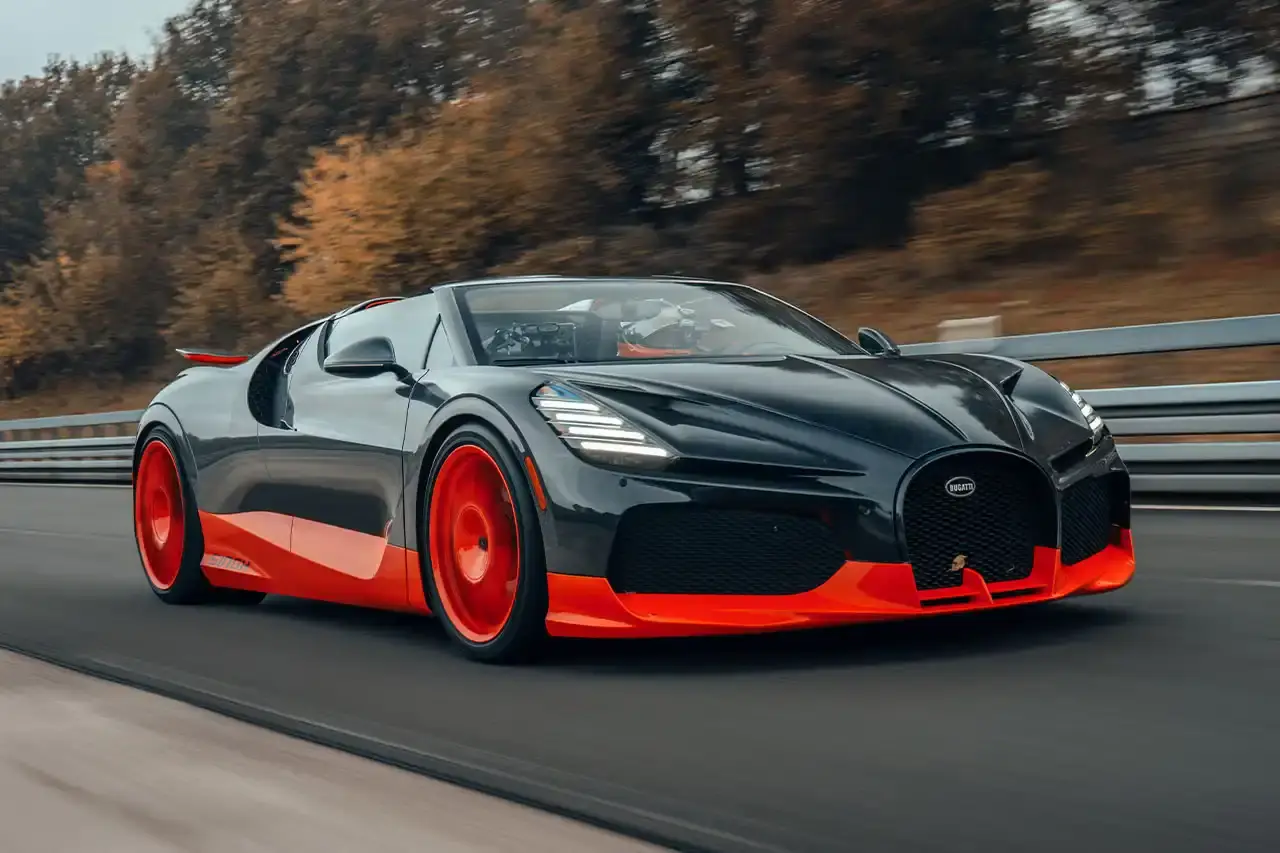 Bugatti Bugatti, the renowned manufacturer of high-performance luxury automobiles, has once again pushed the boundaries of automotive engineering with the remarkable achievements of its W16 Mistral model. On November 9th, the W16 Mistral set a new world record for the fastest open-top car, reaching a staggering speed of 453.91 km/h (281 mph) at the ATP Automotive Testing Papenburg track in Germany. The record-breaking run was piloted by Andy Wallace, Bugatti's official test driver and a renowned Le Mans winner, showcasing the exceptional capabilities of the W16 Mistral. This remarkable feat builds upon Bugatti's legacy of record-setting performance, including the Veyron 16.4 Grand Sport Vitesse's 408.84 km/h (253 mph) record achieved in 2013 and the Chiron Super Sport 300+'s 490.48 km/h (304 mph) closed-cockpit record set in 2019. The W16 Mistral, a bespoke $14.8 million USD model, features a striking black carbon body with "Jet Orange" accents, paying homage to Bugatti's previous record-setting vehicles. The event was attended by Mate Rimac, CEO of Bugatti Rimac, as well as Bugatti's senior team and the vehicle's owner, a collector from Punjab, India. Highlighting the W16 Mistral's prowess, the owner had the opportunity to experience the car's remarkable speed firsthand, joining Wallace for a high-speed run. This latest addition to The Singh Collection joins an exclusive lineup of Bugatti's record-breaking automobiles. (image 3 of 12)