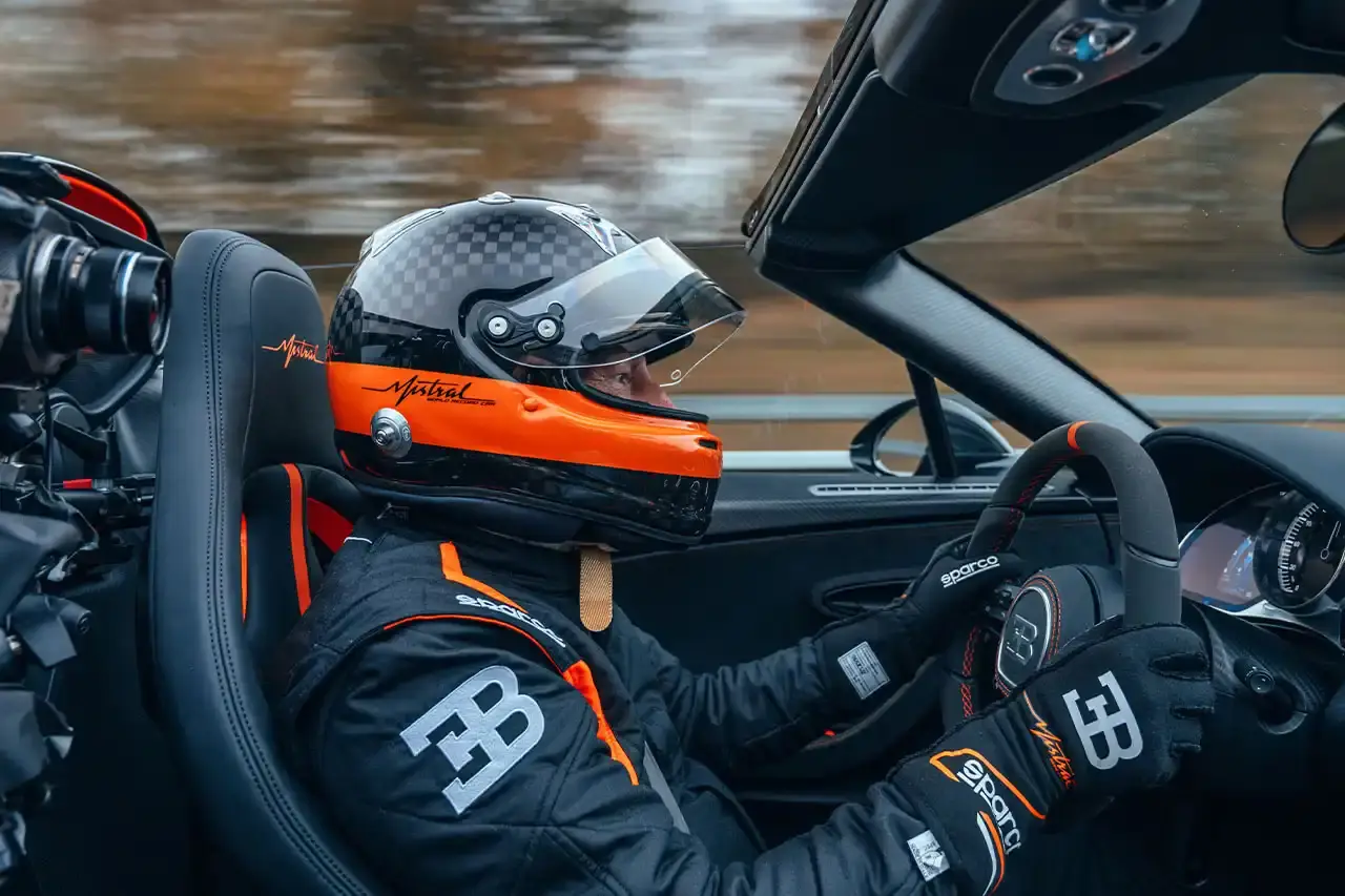 Bugatti Bugatti, the renowned manufacturer of high-performance luxury automobiles, has once again pushed the boundaries of automotive engineering with the remarkable achievements of its W16 Mistral model. On November 9th, the W16 Mistral set a new world record for the fastest open-top car, reaching a staggering speed of 453.91 km/h (281 mph) at the ATP Automotive Testing Papenburg track in Germany. The record-breaking run was piloted by Andy Wallace, Bugatti's official test driver and a renowned Le Mans winner, showcasing the exceptional capabilities of the W16 Mistral. This remarkable feat builds upon Bugatti's legacy of record-setting performance, including the Veyron 16.4 Grand Sport Vitesse's 408.84 km/h (253 mph) record achieved in 2013 and the Chiron Super Sport 300+'s 490.48 km/h (304 mph) closed-cockpit record set in 2019. The W16 Mistral, a bespoke $14.8 million USD model, features a striking black carbon body with "Jet Orange" accents, paying homage to Bugatti's previous record-setting vehicles. The event was attended by Mate Rimac, CEO of Bugatti Rimac, as well as Bugatti's senior team and the vehicle's owner, a collector from Punjab, India. Highlighting the W16 Mistral's prowess, the owner had the opportunity to experience the car's remarkable speed firsthand, joining Wallace for a high-speed run. This latest addition to The Singh Collection joins an exclusive lineup of Bugatti's record-breaking automobiles. (image 7 of 12)