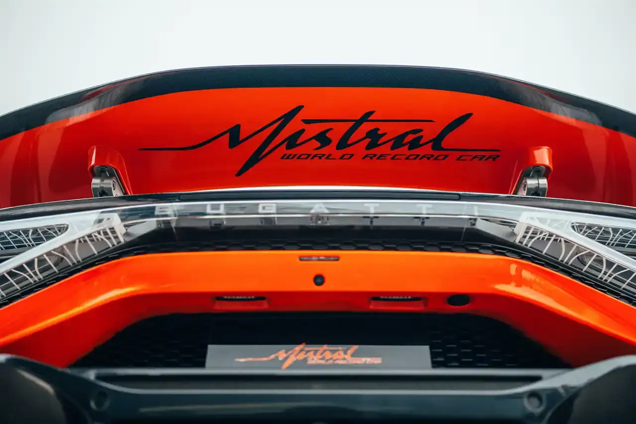 Bugatti Bugatti, the renowned manufacturer of high-performance luxury automobiles, has once again pushed the boundaries of automotive engineering with the remarkable achievements of its W16 Mistral model. On November 9th, the W16 Mistral set a new world record for the fastest open-top car, reaching a staggering speed of 453.91 km/h (281 mph) at the ATP Automotive Testing Papenburg track in Germany. The record-breaking run was piloted by Andy Wallace, Bugatti's official test driver and a renowned Le Mans winner, showcasing the exceptional capabilities of the W16 Mistral. This remarkable feat builds upon Bugatti's legacy of record-setting performance, including the Veyron 16.4 Grand Sport Vitesse's 408.84 km/h (253 mph) record achieved in 2013 and the Chiron Super Sport 300+'s 490.48 km/h (304 mph) closed-cockpit record set in 2019. The W16 Mistral, a bespoke $14.8 million USD model, features a striking black carbon body with "Jet Orange" accents, paying homage to Bugatti's previous record-setting vehicles. The event was attended by Mate Rimac, CEO of Bugatti Rimac, as well as Bugatti's senior team and the vehicle's owner, a collector from Punjab, India. Highlighting the W16 Mistral's prowess, the owner had the opportunity to experience the car's remarkable speed firsthand, joining Wallace for a high-speed run. This latest addition to The Singh Collection joins an exclusive lineup of Bugatti's record-breaking automobiles. (image 5 of 12)