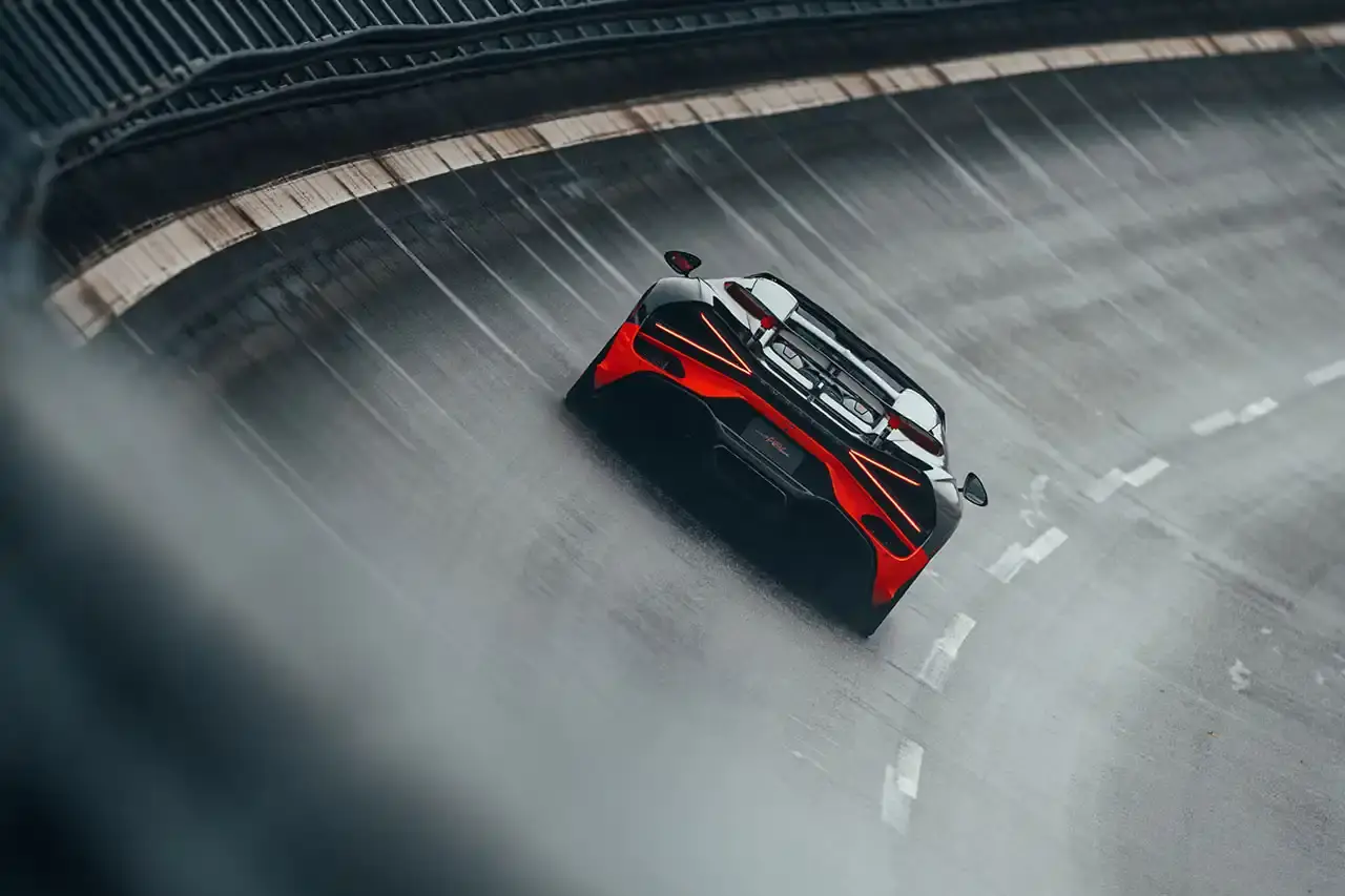 Bugatti Bugatti, the renowned manufacturer of high-performance luxury automobiles, has once again pushed the boundaries of automotive engineering with the remarkable achievements of its W16 Mistral model. On November 9th, the W16 Mistral set a new world record for the fastest open-top car, reaching a staggering speed of 453.91 km/h (281 mph) at the ATP Automotive Testing Papenburg track in Germany. The record-breaking run was piloted by Andy Wallace, Bugatti's official test driver and a renowned Le Mans winner, showcasing the exceptional capabilities of the W16 Mistral. This remarkable feat builds upon Bugatti's legacy of record-setting performance, including the Veyron 16.4 Grand Sport Vitesse's 408.84 km/h (253 mph) record achieved in 2013 and the Chiron Super Sport 300+'s 490.48 km/h (304 mph) closed-cockpit record set in 2019. The W16 Mistral, a bespoke $14.8 million USD model, features a striking black carbon body with "Jet Orange" accents, paying homage to Bugatti's previous record-setting vehicles. The event was attended by Mate Rimac, CEO of Bugatti Rimac, as well as Bugatti's senior team and the vehicle's owner, a collector from Punjab, India. Highlighting the W16 Mistral's prowess, the owner had the opportunity to experience the car's remarkable speed firsthand, joining Wallace for a high-speed run. This latest addition to The Singh Collection joins an exclusive lineup of Bugatti's record-breaking automobiles. (image 11 of 12)