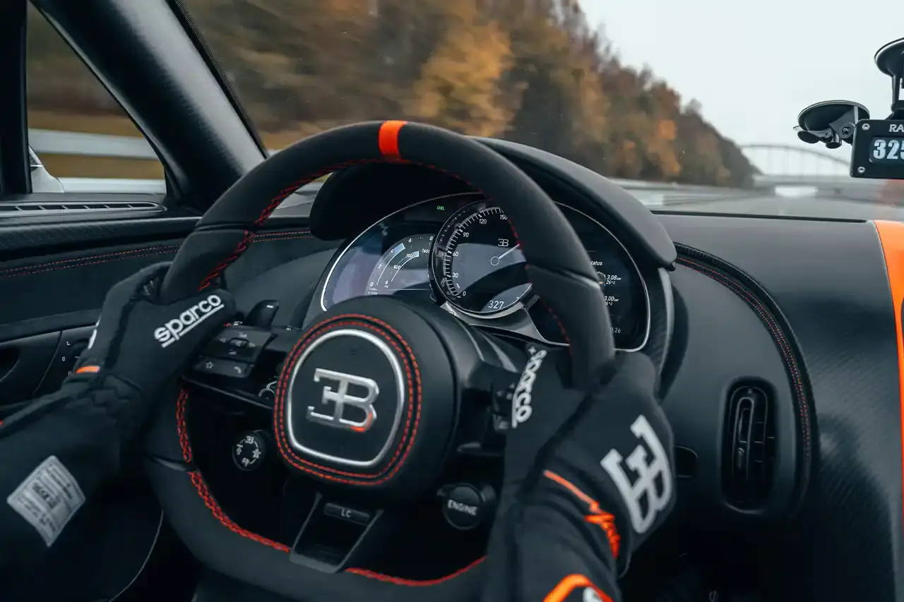 Bugatti Bugatti, the renowned manufacturer of high-performance luxury automobiles, has once again pushed the boundaries of automotive engineering with the remarkable achievements of its W16 Mistral model. On November 9th, the W16 Mistral set a new world record for the fastest open-top car, reaching a staggering speed of 453.91 km/h (281 mph) at the ATP Automotive Testing Papenburg track in Germany. The record-breaking run was piloted by Andy Wallace, Bugatti's official test driver and a renowned Le Mans winner, showcasing the exceptional capabilities of the W16 Mistral. This remarkable feat builds upon Bugatti's legacy of record-setting performance, including the Veyron 16.4 Grand Sport Vitesse's 408.84 km/h (253 mph) record achieved in 2013 and the Chiron Super Sport 300+'s 490.48 km/h (304 mph) closed-cockpit record set in 2019. The W16 Mistral, a bespoke $14.8 million USD model, features a striking black carbon body with "Jet Orange" accents, paying homage to Bugatti's previous record-setting vehicles. The event was attended by Mate Rimac, CEO of Bugatti Rimac, as well as Bugatti's senior team and the vehicle's owner, a collector from Punjab, India. Highlighting the W16 Mistral's prowess, the owner had the opportunity to experience the car's remarkable speed firsthand, joining Wallace for a high-speed run. This latest addition to The Singh Collection joins an exclusive lineup of Bugatti's record-breaking automobiles. (image 6 of 12)