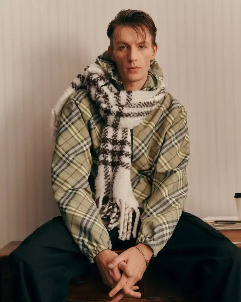BURBERRY RETURNS TO HOUSE CODES FOR SPRING 2026 Article reviewing Burberry's Spring 2026 menswear collection, featuring heritage-inspired pieces including trench coats, knitwear, and accessories with signature house patterns. (image 14 of 19)
