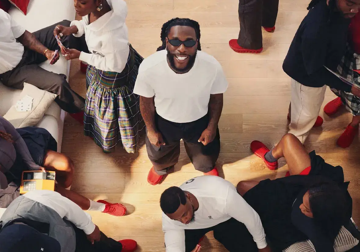 BURNA BOY AND ON RELEASE FIRST SNEAKER COLLECTION image about the first footwear collection from On and Burna Boy. It covers the all-red Cloudmonster BB, the white THE ROGER Clubhouse BB, prices in dollars and euros, the campaign and where to buy.