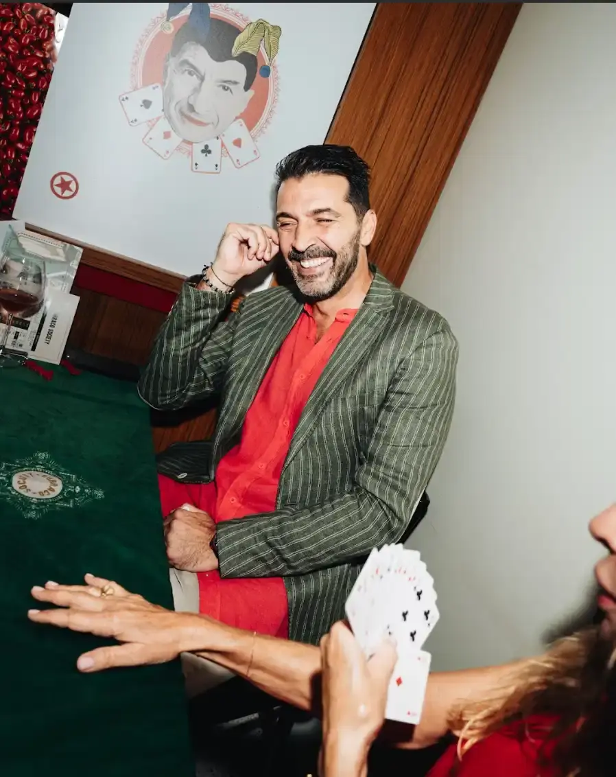 BURRACO NIGHT AT SUGO MILANO WITH CATTELAN AND BUFFON photo by Matteo Vetrano During Milan Fashion Week, Maurizio Cattelan and Paride Vitale hosted a Burraco card game night at Sugo restaurant. Supported by Dal Negro card makers, the event brought together fashion insiders, designers, and guests including footballer Gigi Buffon. The traditional Milanese card game replaced typical fashion parties with a focus on play and connection. Attendees shared food from Sugo's kitchen while playing matches at tables filled with cards and wine. The night shifted Fashion Week's usual pace to something slower and more social, bringing living room culture to the center of the fashion calendar. (image 9 of 13)