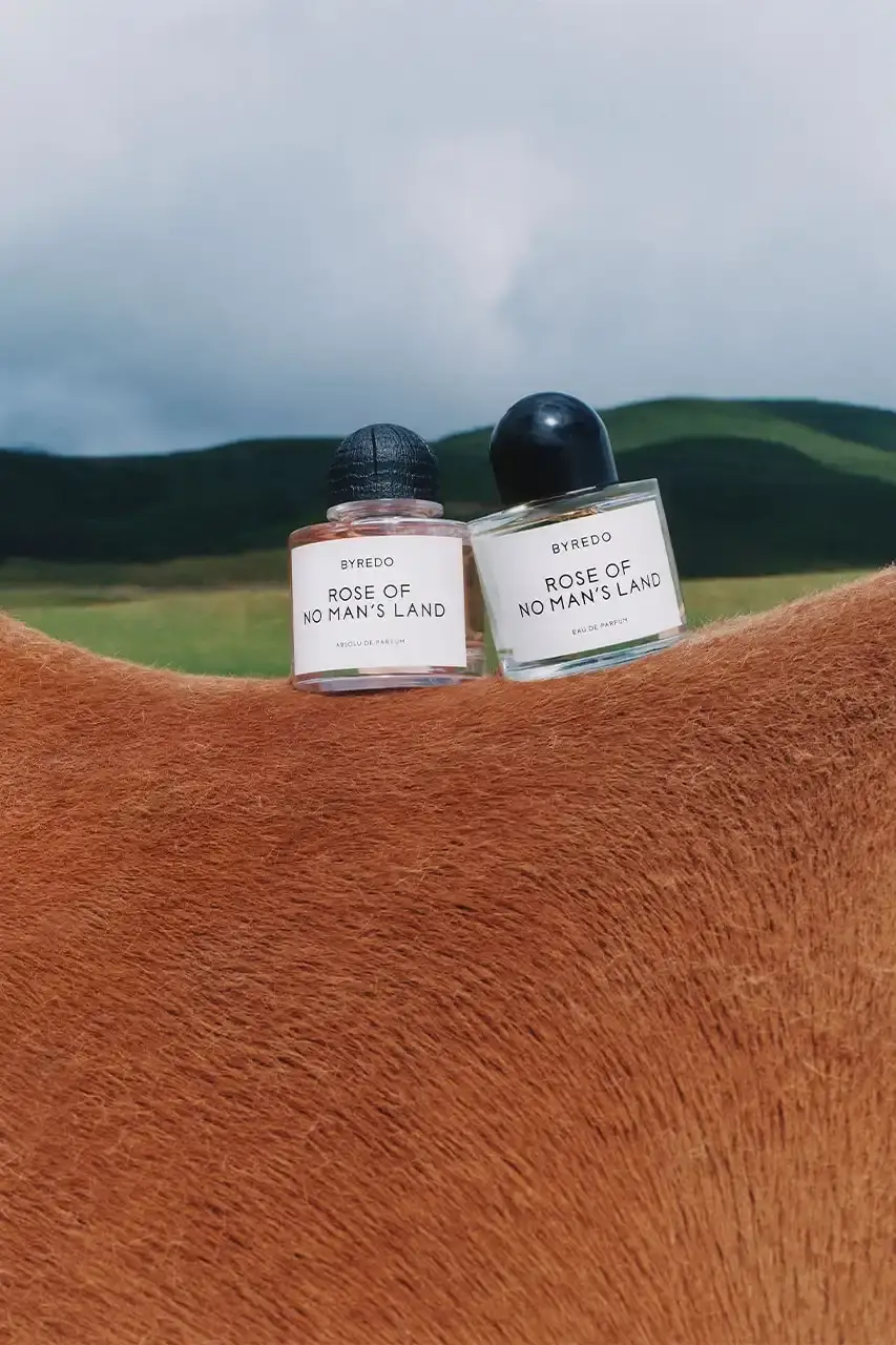 BYREDO MARKS LUNAR NEW YEAR WITH HORSE-THEMED CAMPAIGN Byredo releases Lunar New Year campaign featuring two fragrances, Rose of No Man's Land and Desert Dawn, photographed by Annie Lai with models Xi Yi and Wang Xuan in natural settings, drawing inspiration from Swedish Dala horse symbolism. (image 1 of 4)