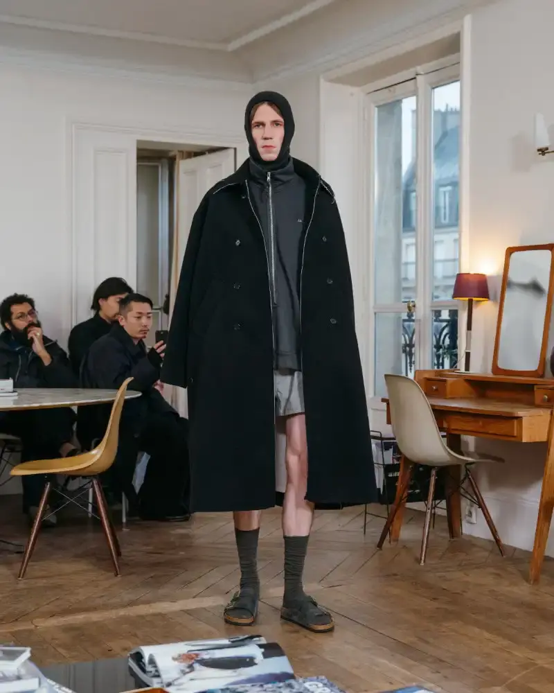 CAMIEL FORTGENS REWORKS DOMESTIC MATERIALS FOR FW26 Camiel Fortgens Fall/Winter 2026 collection shown in Paris apartment, featuring garments made from domestic materials like curtain pleats and sofa leather in earthy tones. (image 4 of 19)
