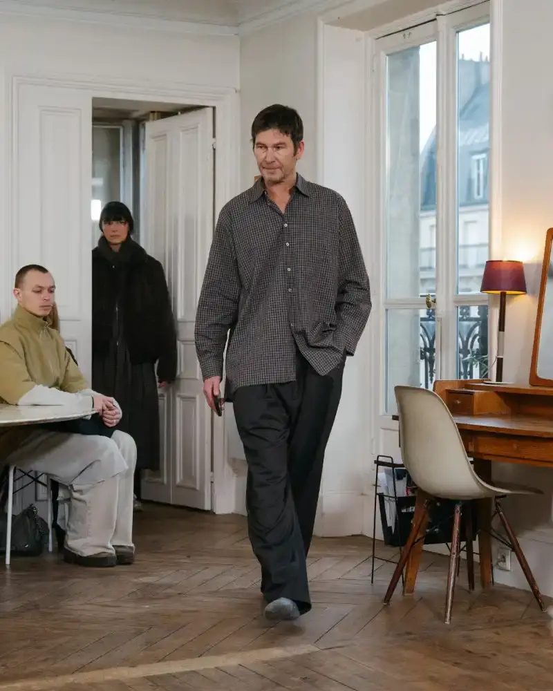 CAMIEL FORTGENS REWORKS DOMESTIC MATERIALS FOR FW26 Camiel Fortgens Fall/Winter 2026 collection shown in Paris apartment, featuring garments made from domestic materials like curtain pleats and sofa leather in earthy tones. (image 17 of 19)