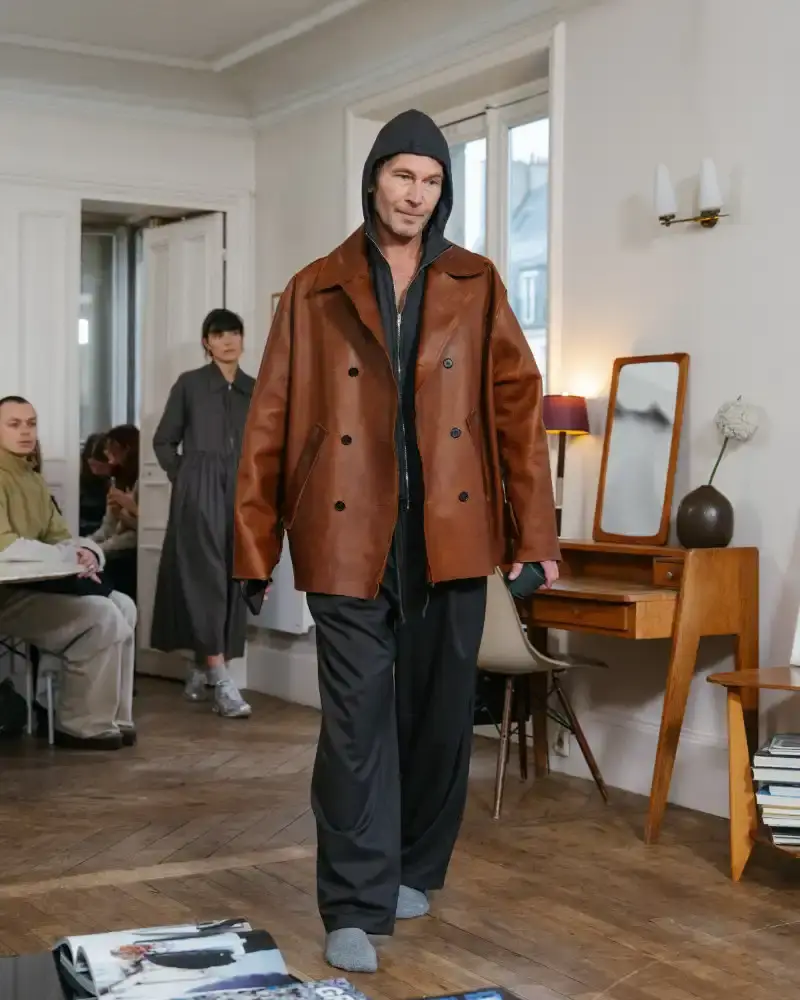 CAMIEL FORTGENS REWORKS DOMESTIC MATERIALS FOR FW26 Camiel Fortgens Fall/Winter 2026 collection shown in Paris apartment, featuring garments made from domestic materials like curtain pleats and sofa leather in earthy tones. (image 14 of 19)