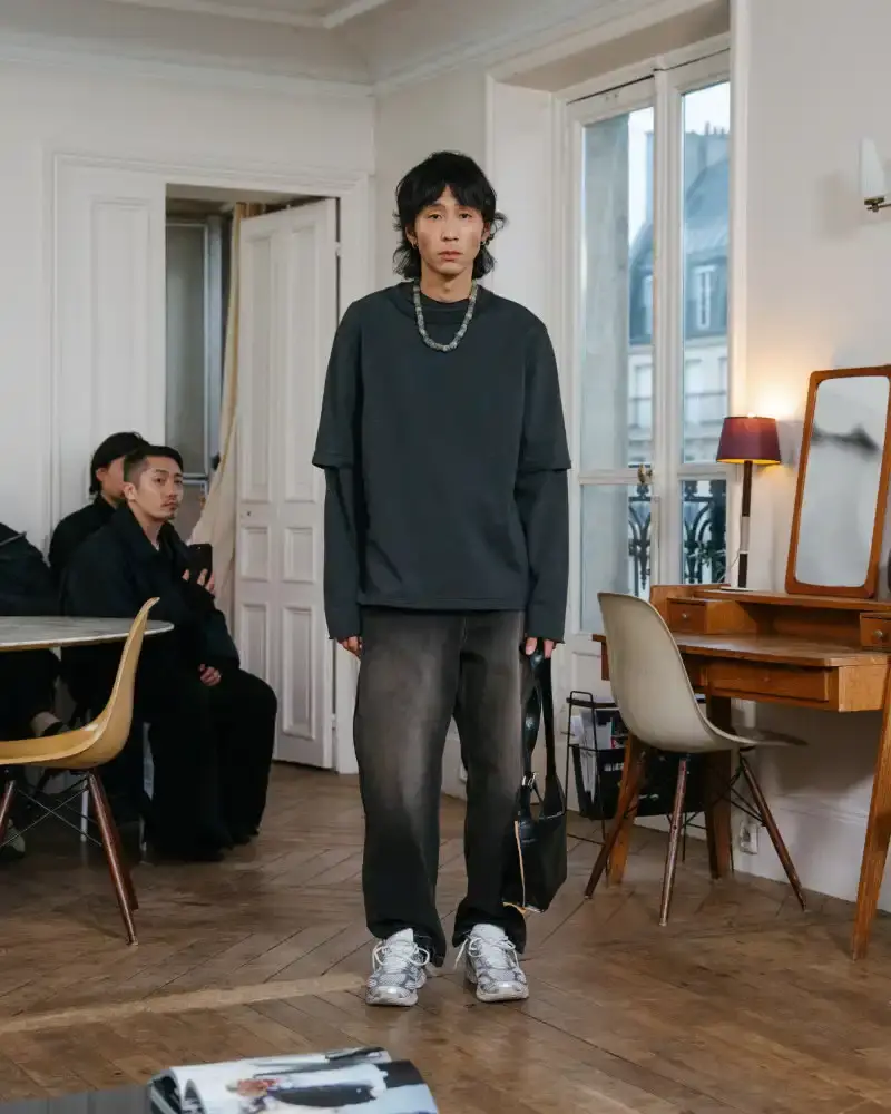 CAMIEL FORTGENS REWORKS DOMESTIC MATERIALS FOR FW26 Camiel Fortgens Fall/Winter 2026 collection shown in Paris apartment, featuring garments made from domestic materials like curtain pleats and sofa leather in earthy tones. (image 5 of 19)