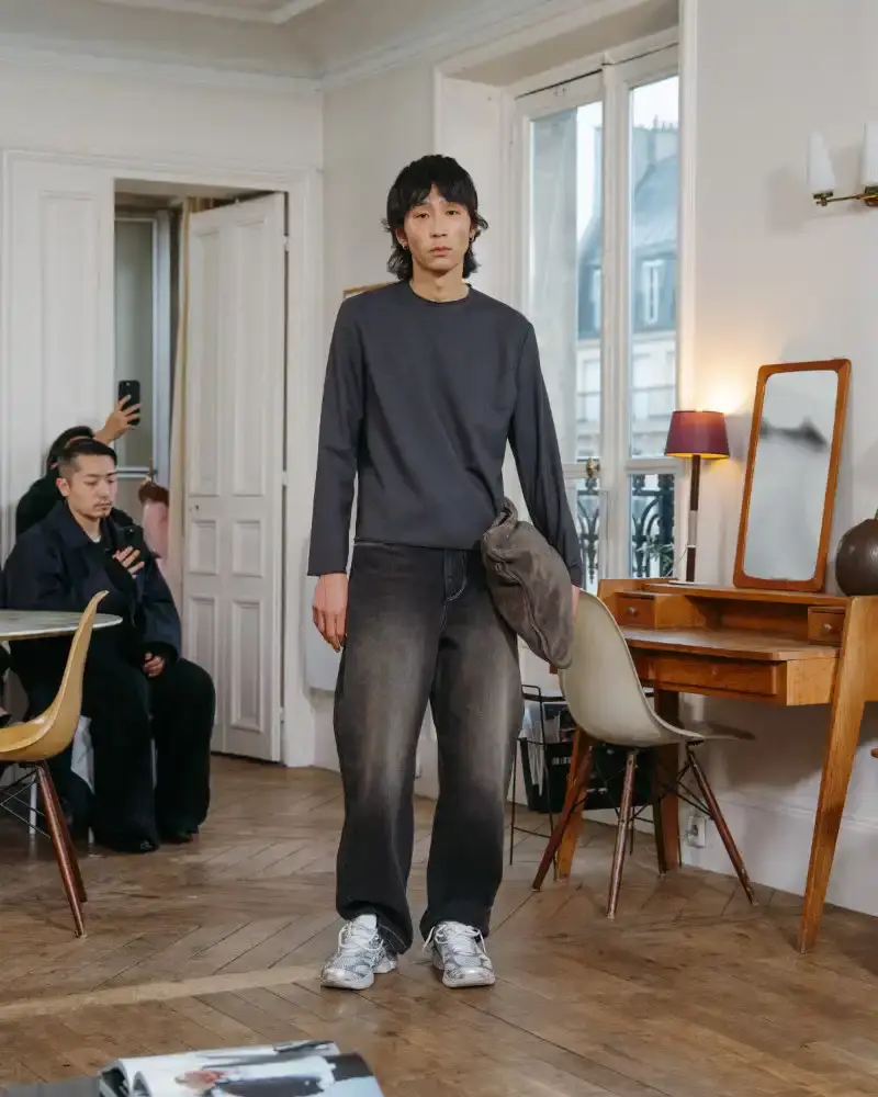 CAMIEL FORTGENS REWORKS DOMESTIC MATERIALS FOR FW26 Camiel Fortgens Fall/Winter 2026 collection shown in Paris apartment, featuring garments made from domestic materials like curtain pleats and sofa leather in earthy tones. (image 11 of 19)